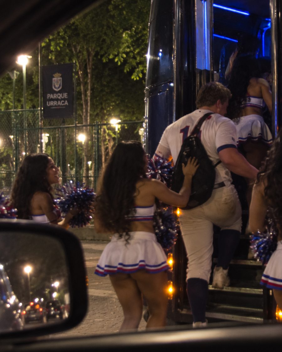 El lanzador subiendo a un bus acompañado del equipo de porristas